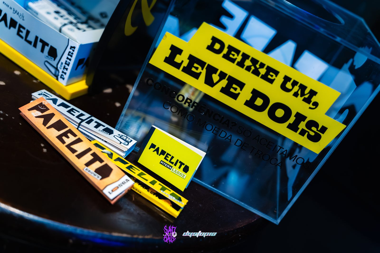 Urna da mecânica “Deixe um, leve dois” cercada de sedas Papelito
